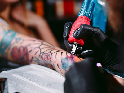 Person tattooing another