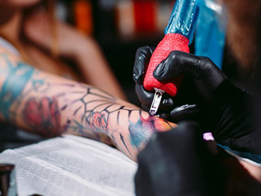 Someone receiving a colorful tattoo on their arm